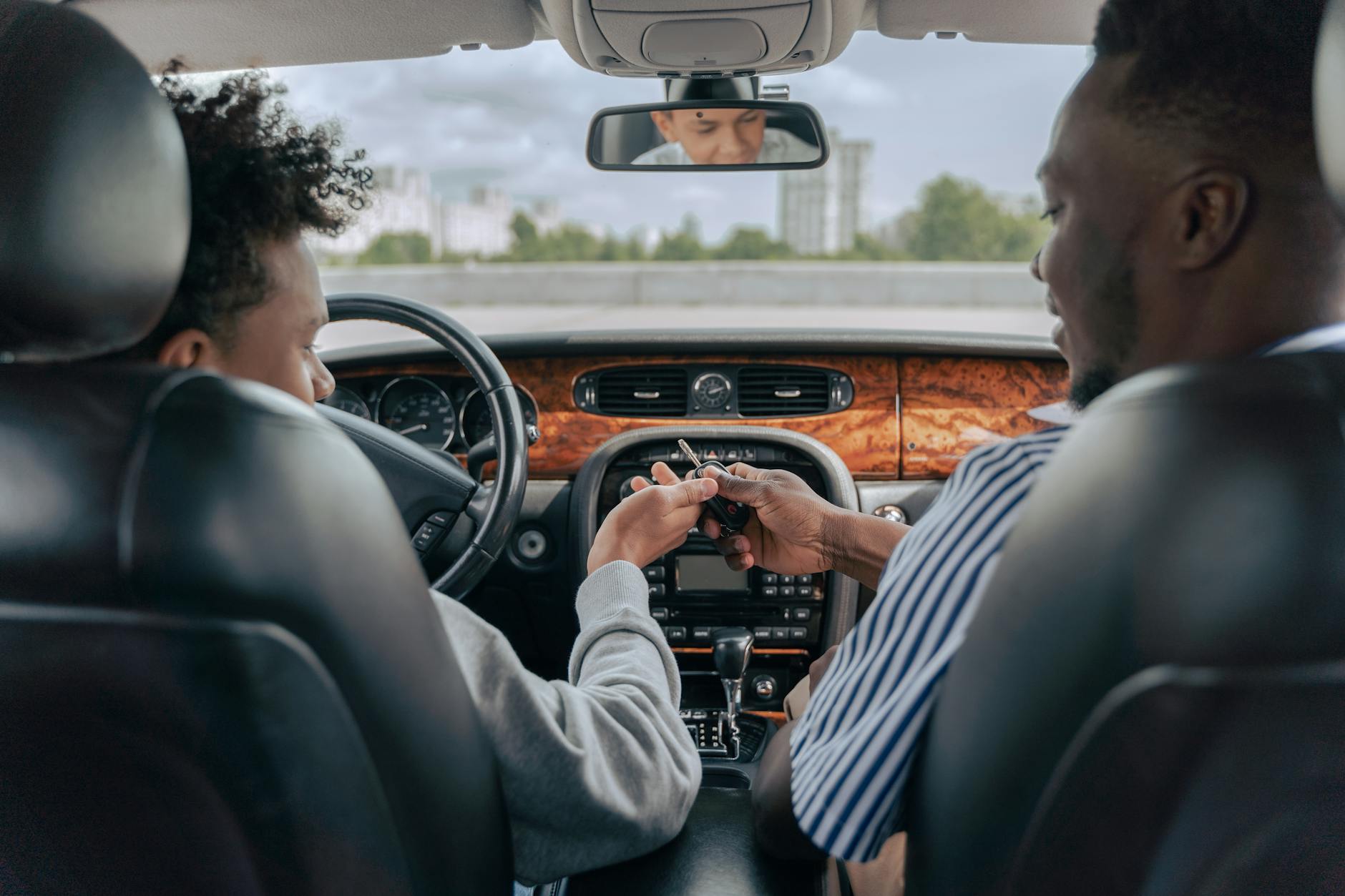 Ojciec uczy nastoletniego syna prowadzić auto w trakcie jazdy