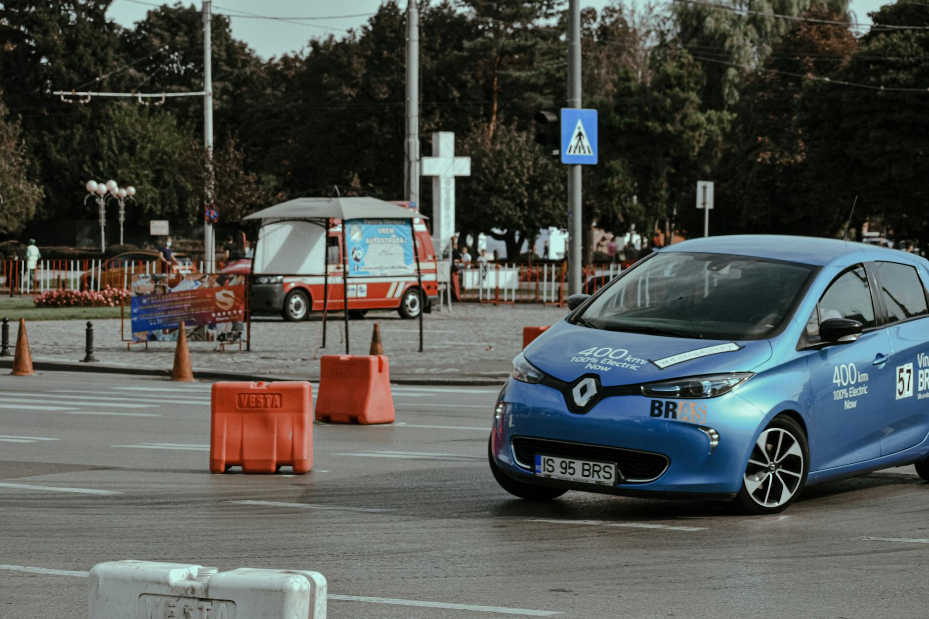 Niebieska Tesla jedzie po asfaltowym torze wyścigowym w centrum miasta