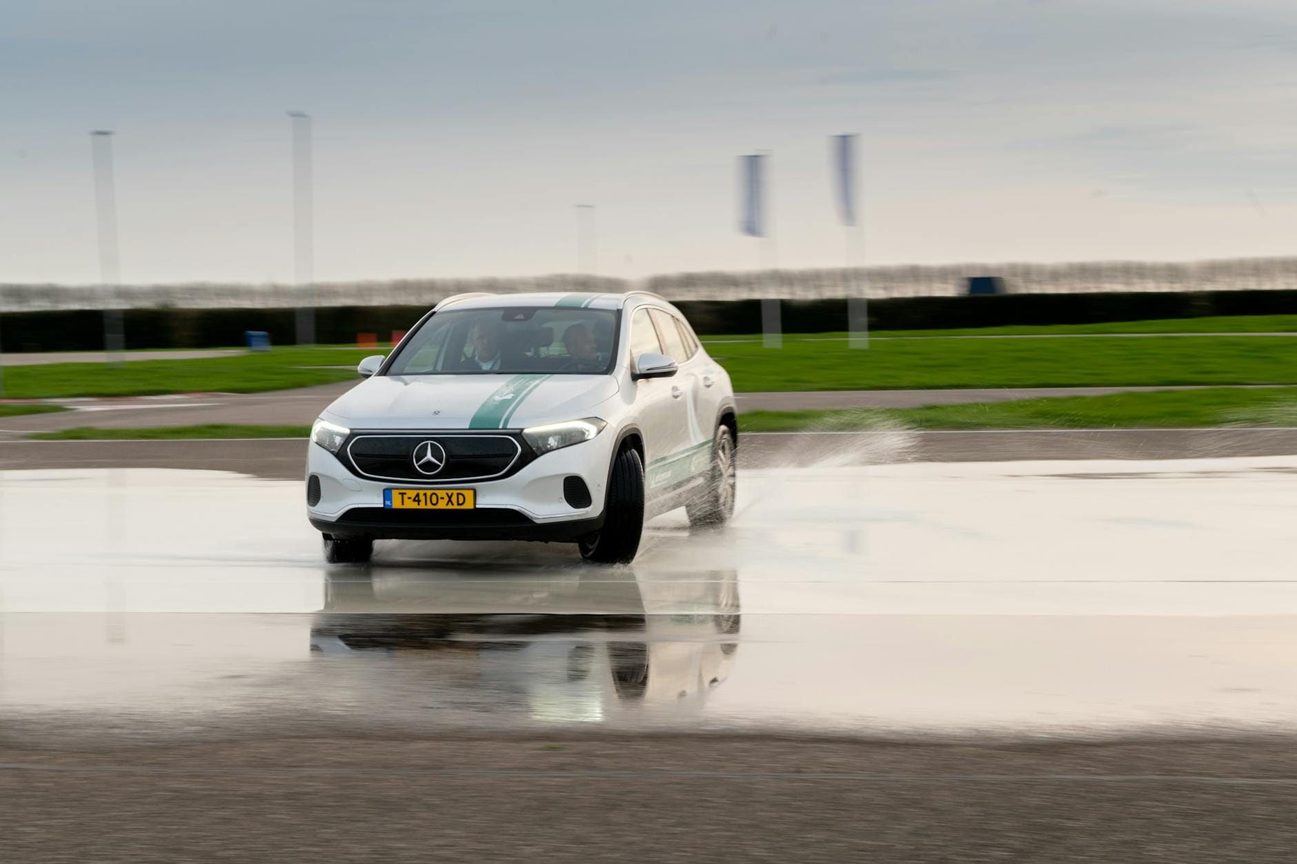 Srebrny Mercedes trenujący kontrolę poślizgu na mokrym torze Srebrny Mercedes trenujący kontrolę poślizgu na mokrym torze