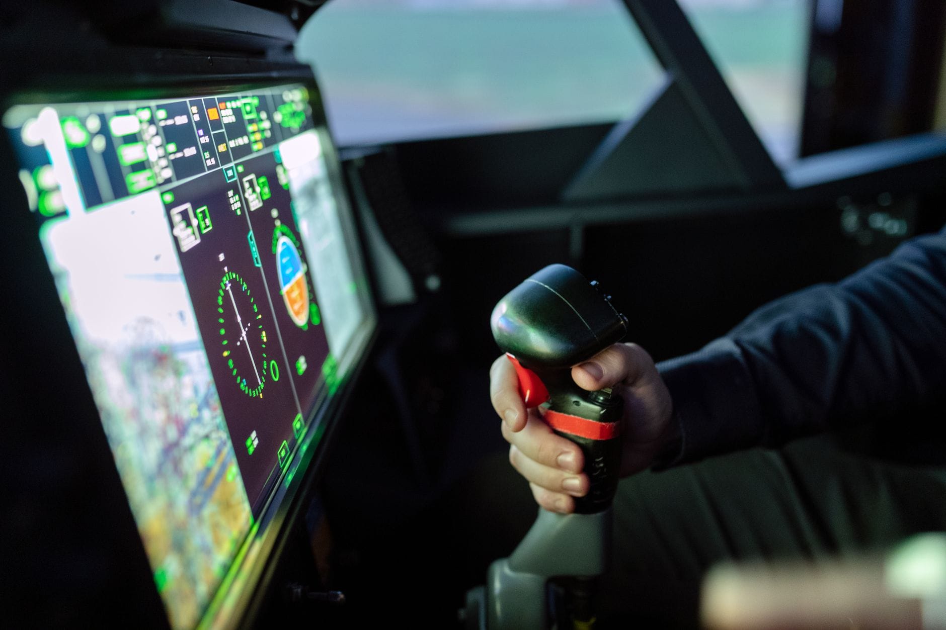 Zbliżenie na symulator kokpitu z joystickiem i cyfrowymi wskaźnikami