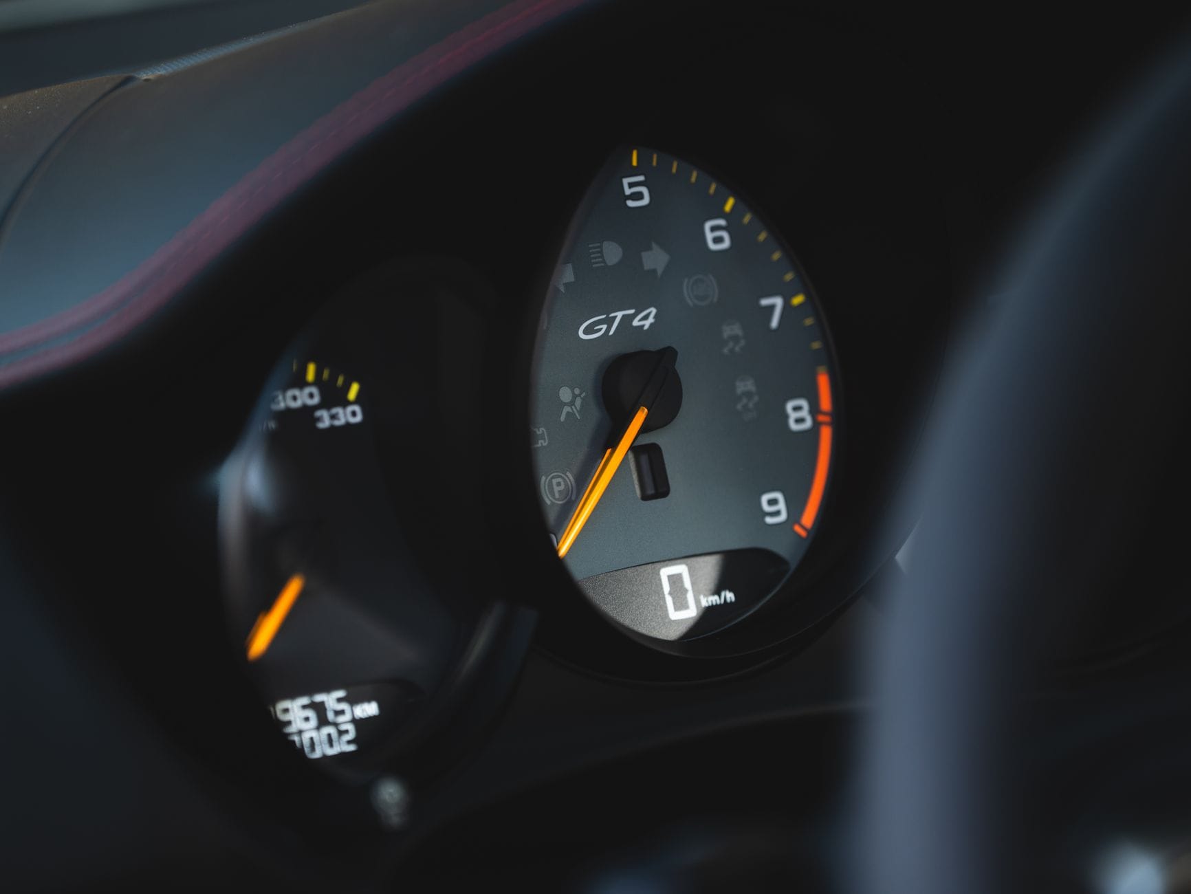 Zbliżenie na prędkościomierz Porsche GT4 na desce rozdzielczej