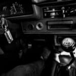 Manual czy automat w Porsche: który lepszy dla kierowców świeżo po egzaminie państwowym Czarno-białe wnętrze zabytkowego auta z manualną skrzynią biegów