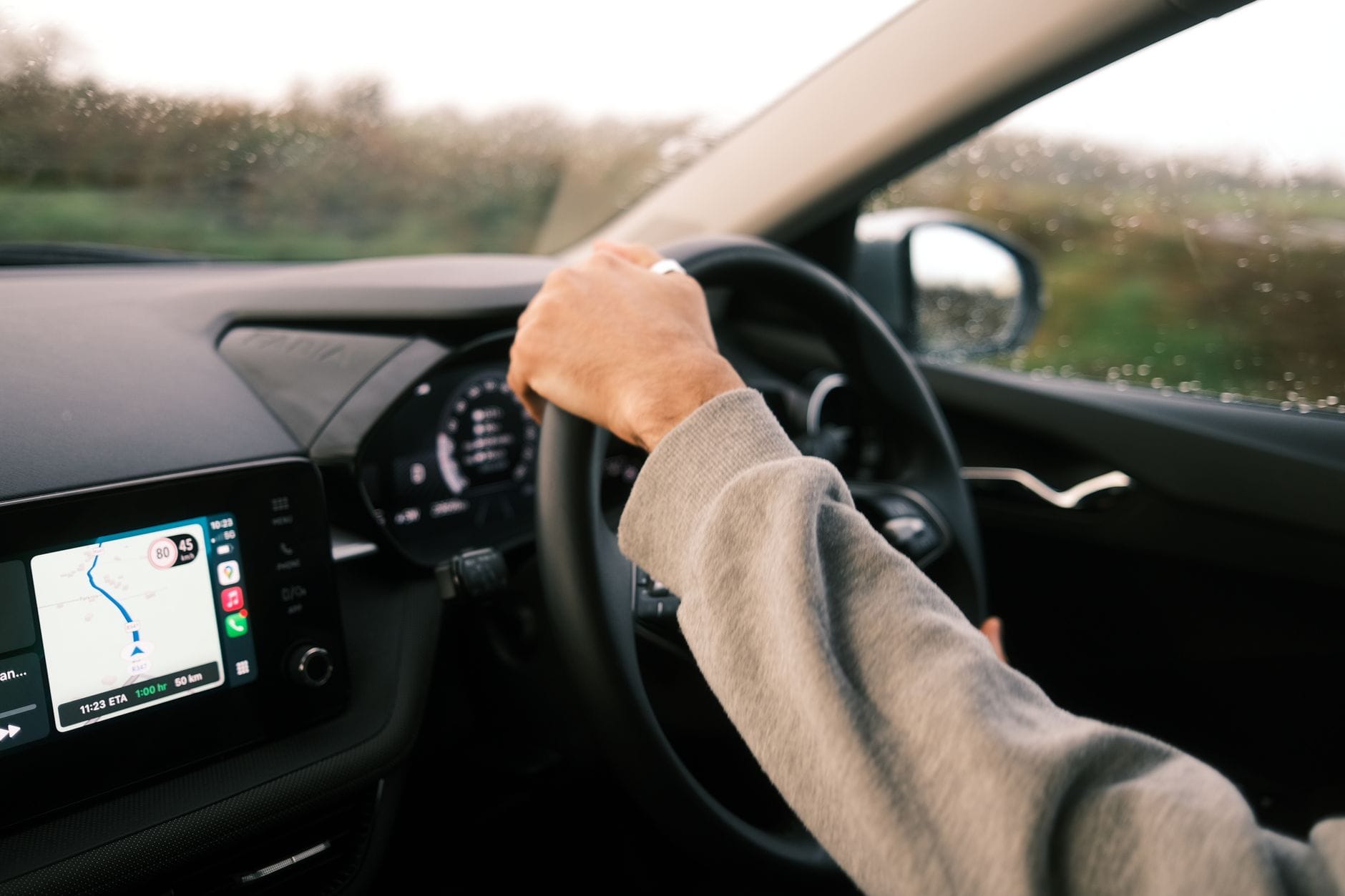 Kierowca jedzie w deszczu, na desce rozdzielczej włączony GPS