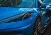 Niebieskie Porsche nocą odbijające światła miasta
