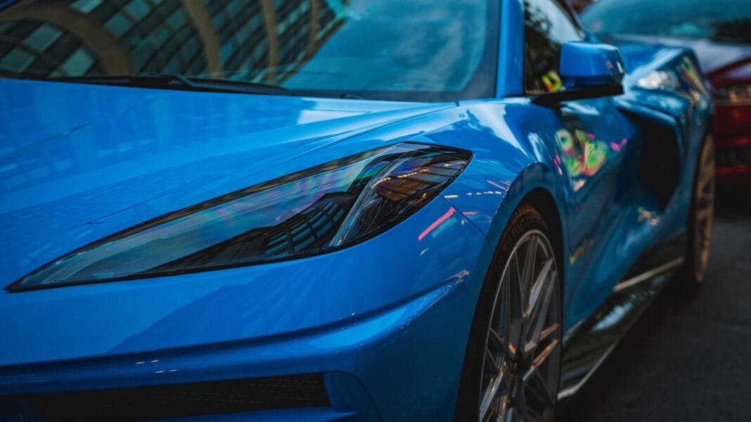 Niebieskie Porsche nocą odbijające światła miasta Niebieskie Porsche nocą odbijające światła miasta