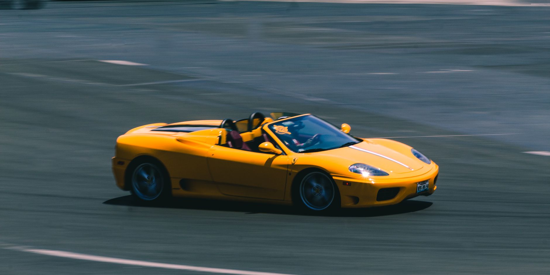 Żółte sportowe Ferrari cabrio pędzące po torze wyścigowym